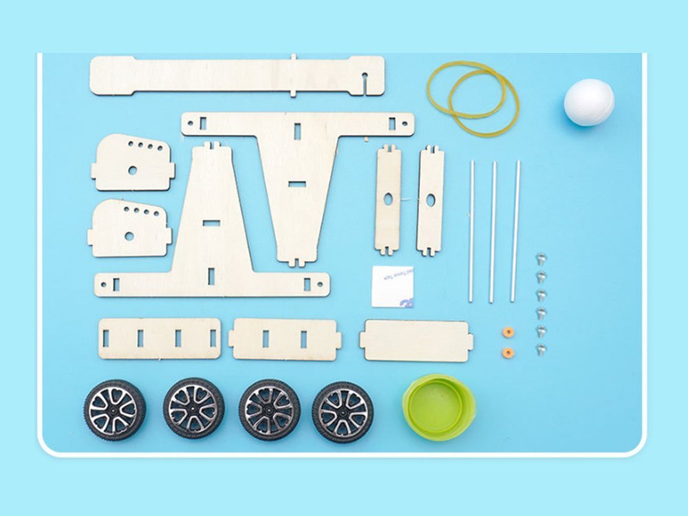 Every part in the Catapult kit laid out: plywood plates, wheels, rubber bands, foam ball, cup and hardware